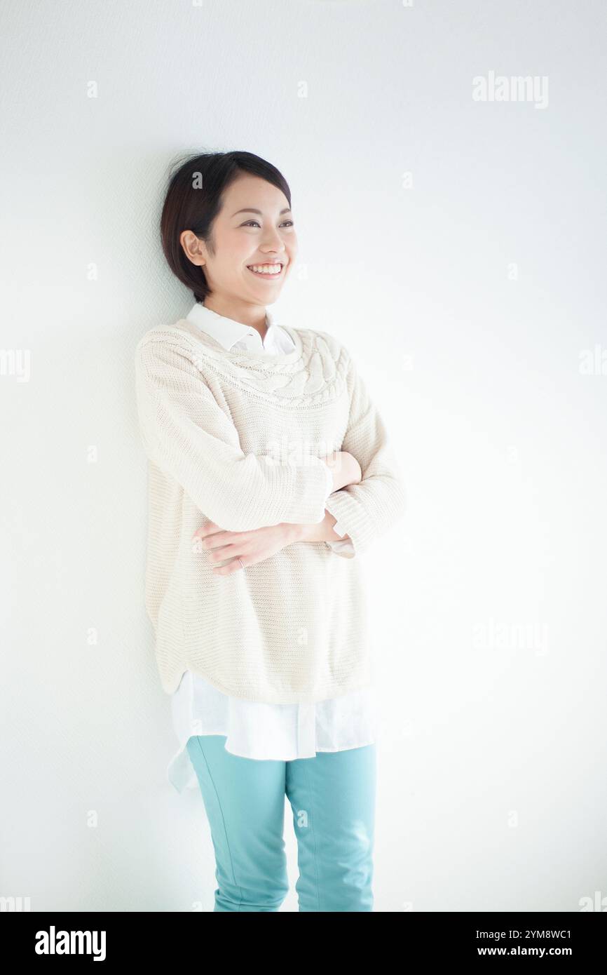 Smiling Japanese woman in her 20s folding her arms Stock Photo - Alamy