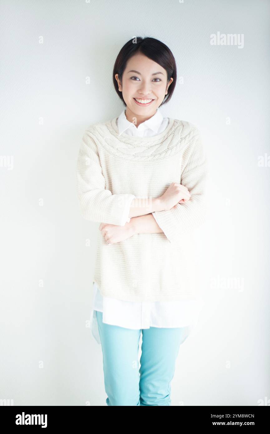 Smiling Japanese woman in her 20s folding her arms Stock Photo - Alamy