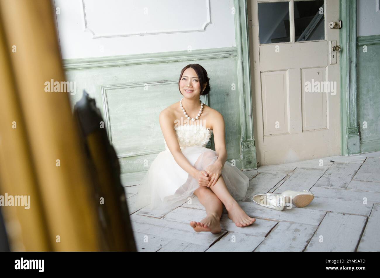 Woman sitting on floor wearing white dress Stock Photo - Alamy