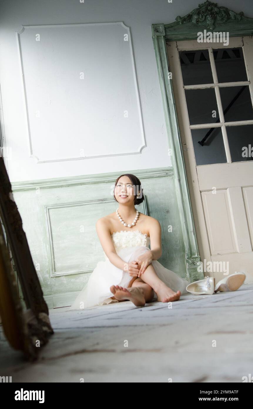 Woman sitting on floor wearing white dress Stock Photo - Alamy
