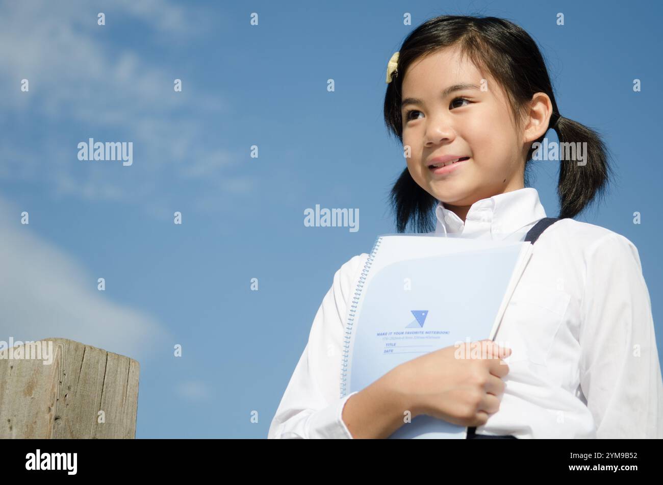Primary school girl holding notebook Stock Photo - Alamy