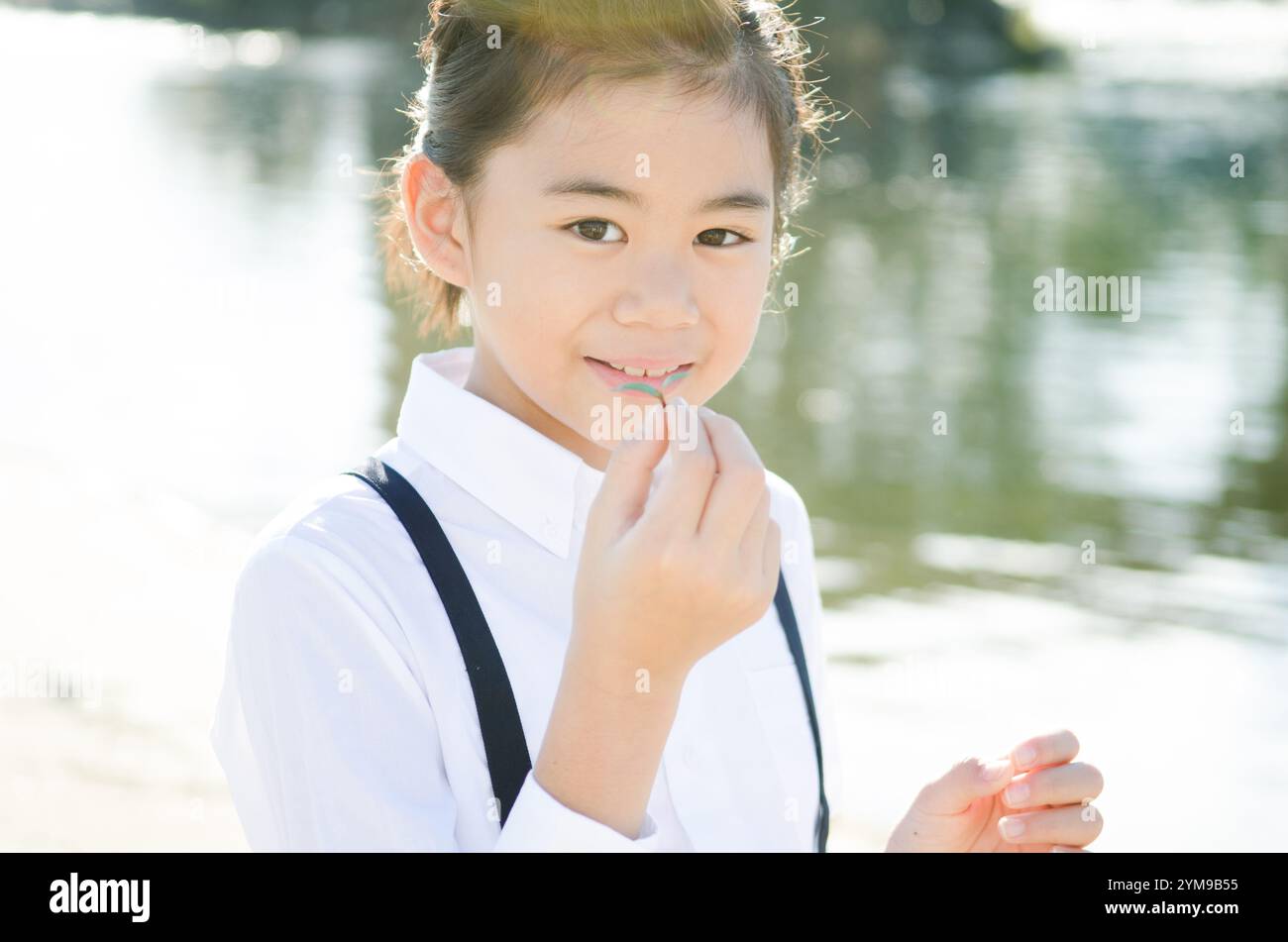 Primary school girl laughing holding a twin leaf Stock Photo