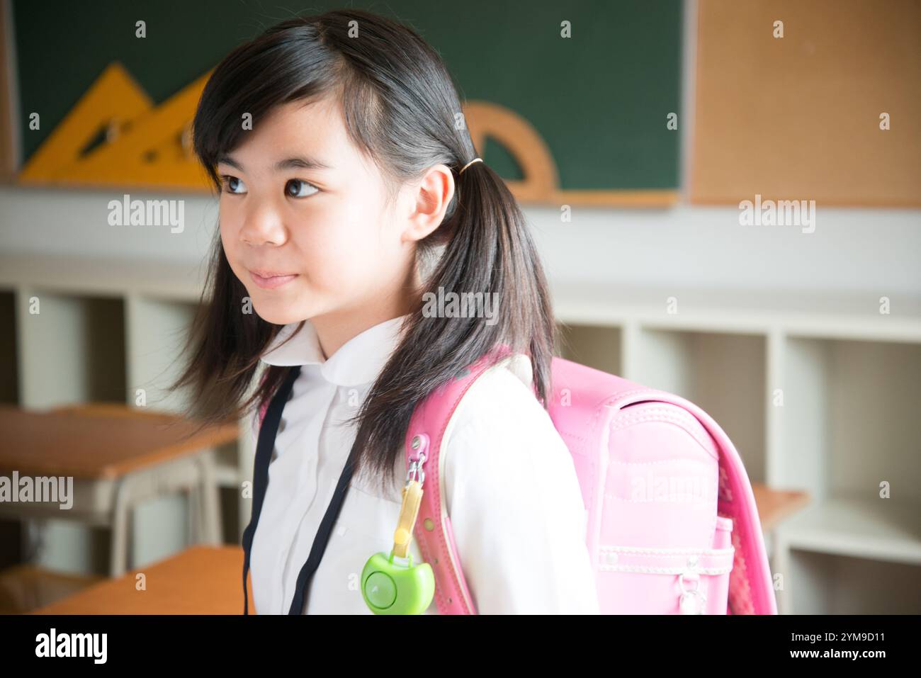 Primary school girl with school bag on her back Stock Photo - Alamy