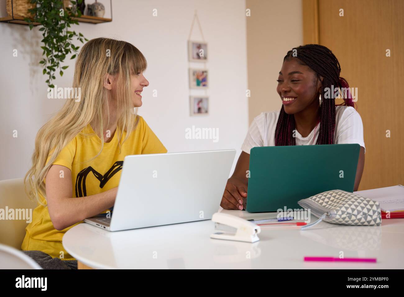 Multiethnic students collaborating on laptops: promoting diversity and education Stock Photo