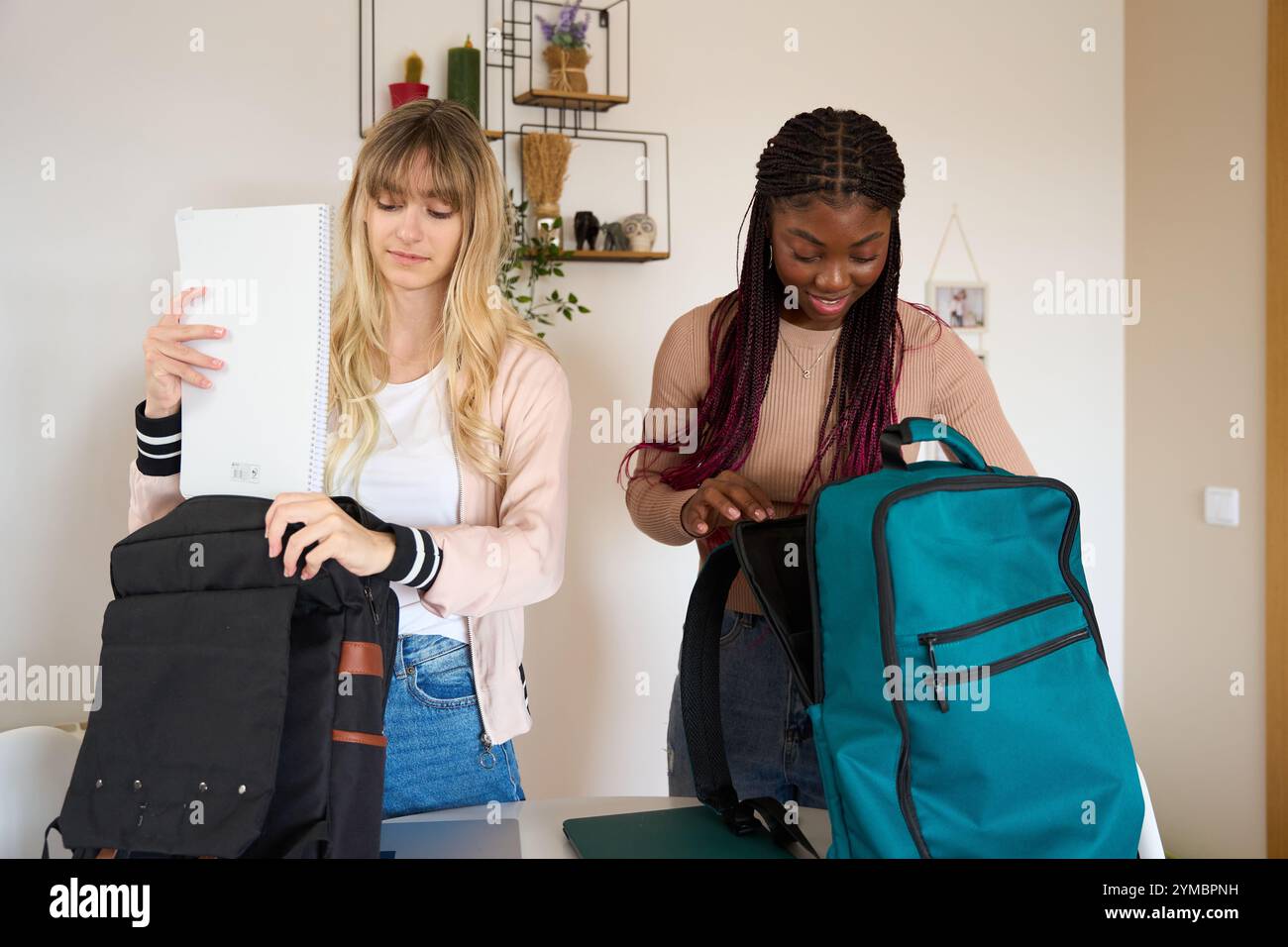 Multiethnic students preparing backpacks at home Stock Photo