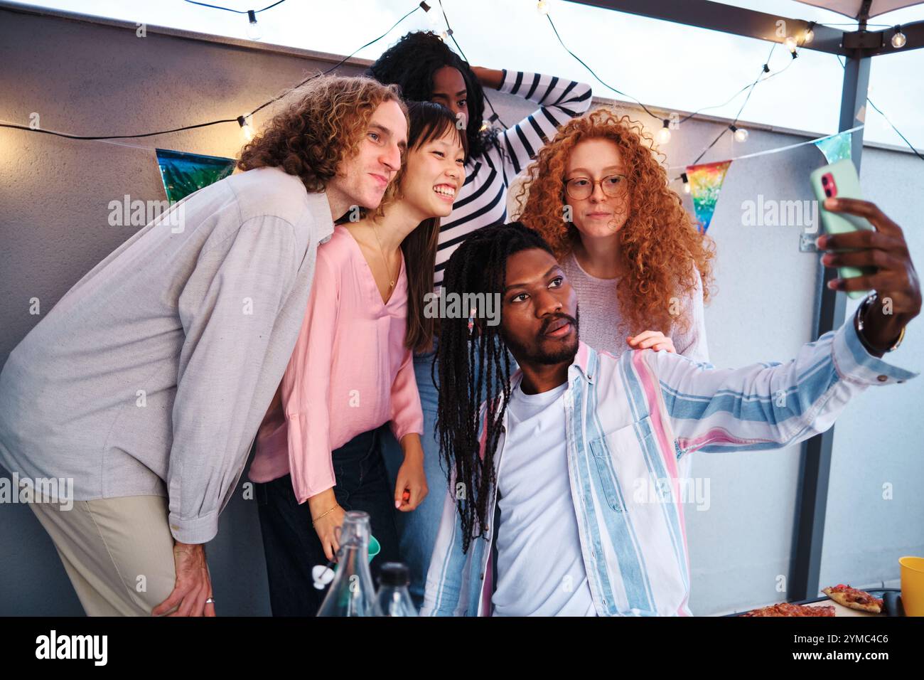 Multiethnic friends taking a selfie at rooftop party Stock Photo - Alamy