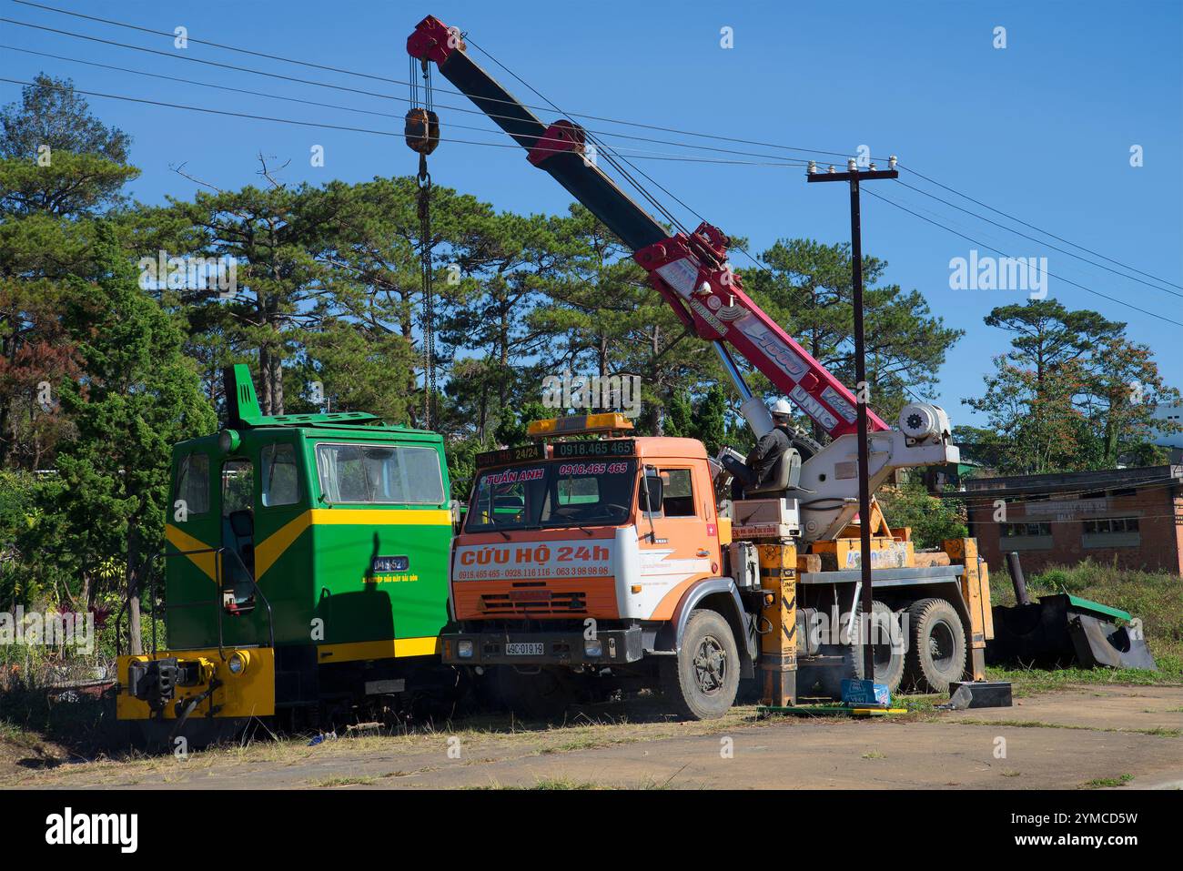 DALAT, VIETNAM - DECEMBER 27, 2015: Repair of a diesel locomotive using a crane on the chassis of a Russian KamAZ-64112 car at the railway station Stock Photo