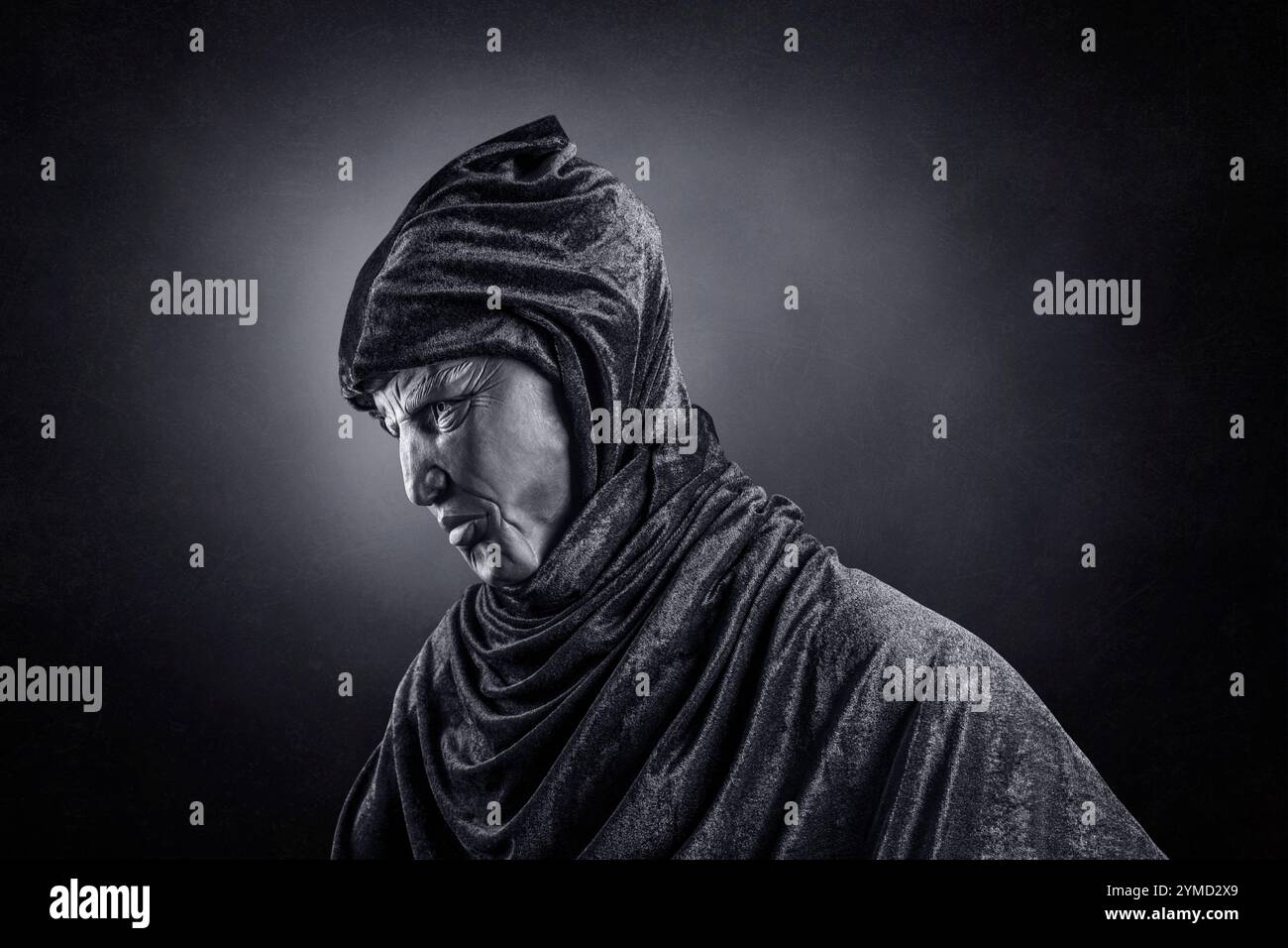 Scary figure with hooded cloak in the dark Stock Photo