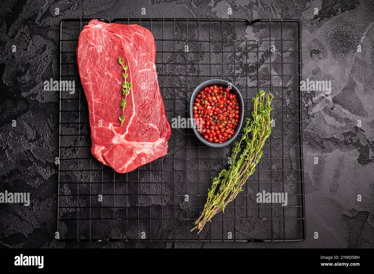 Sirloin Rack Raw top sirloin beef steak with thyme on a rack. black background. top ...