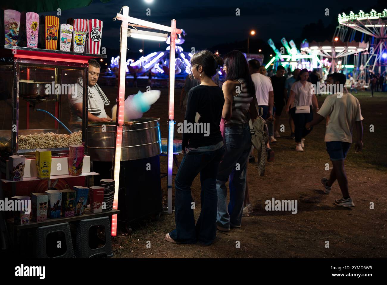 Guca, Serbia - 4 August 2024: Street food stand with cotton candy and popcorn with fairfair in the background at Guca Trumpet Festival, traditional an Stock Photo