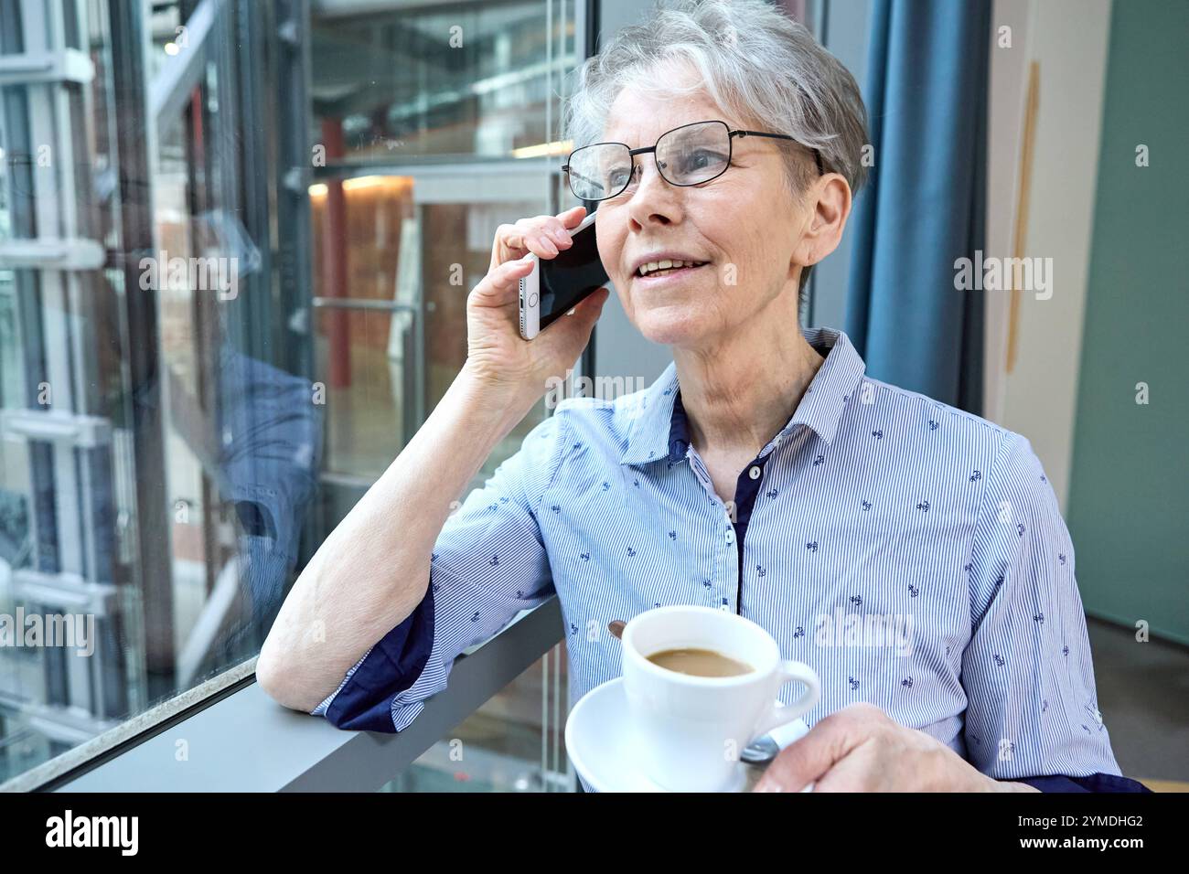 17 November 2024: An experienced senior citizen combines tradition and modernity. She is on the phone with her smartphone and coffee in her hand, symbolizing senior citizens in the digital age *** Eine erfahrene Seniorin verbindet Tradition und Moderne. Sie telefoniert mit dem Smartphone und Kaffee in der Hand, symbolisch für Senioren im digitalen Zeitalter Stock Photo