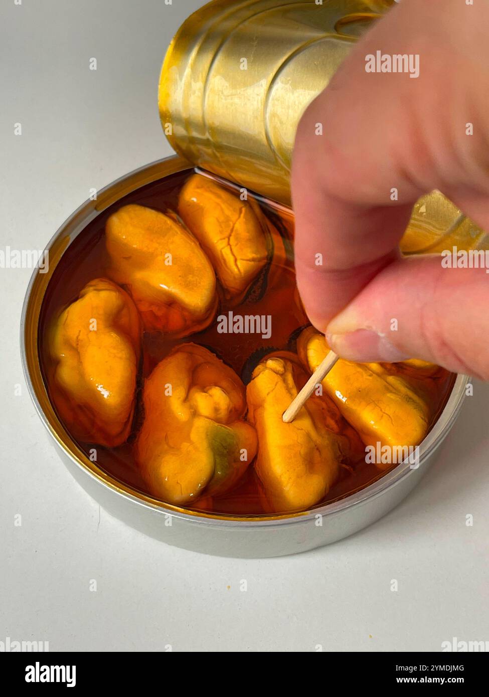 Hand taking a canned mussel. - Smartphone Captured Stock Image