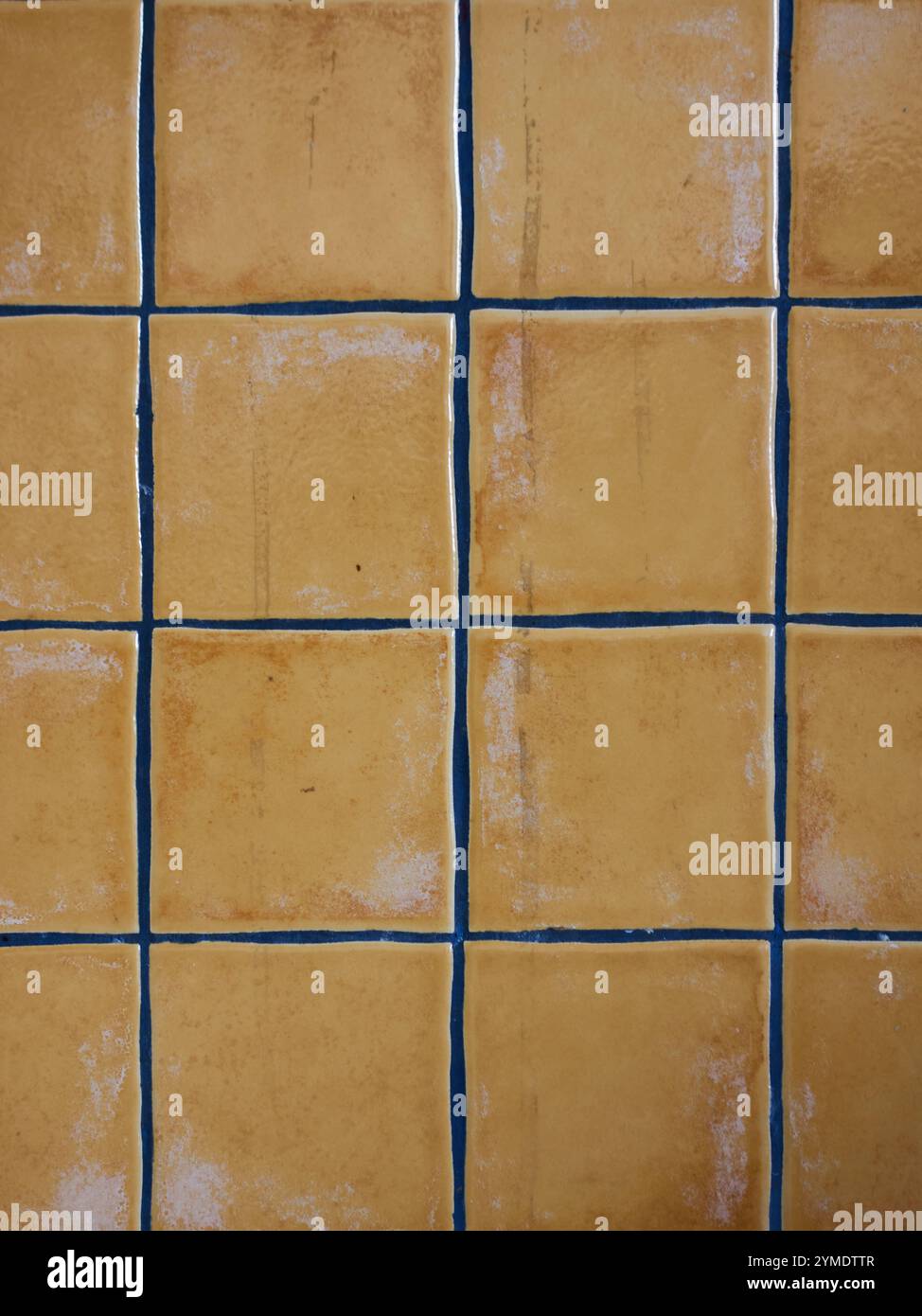 Bright yellow square tiles arranged in a grid pattern with white grout ...