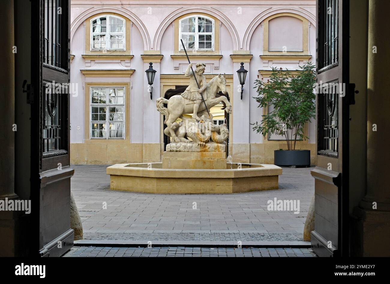 A fountain with a statue depicting St. George slaying a dragon stands in a courtyard at Bratislava's historic Primate’s Palace. Stock Photo