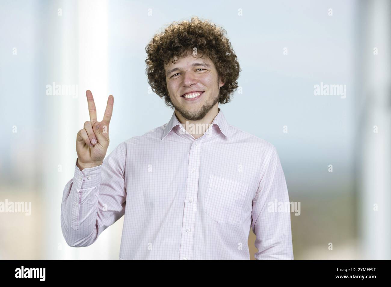 Victory sign young man curly hi-res stock photography and images - Alamy