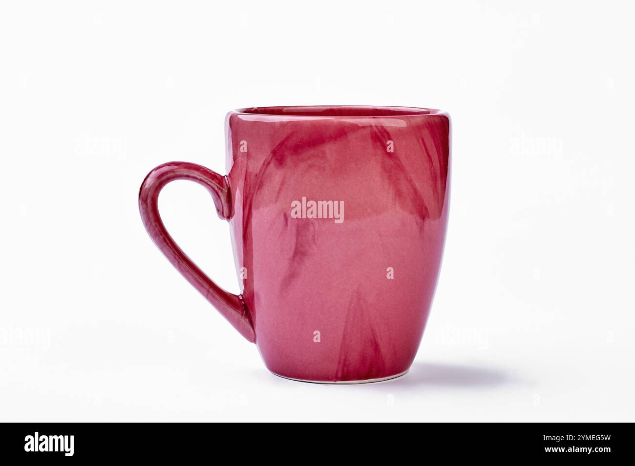 Ceramic mug on white backdrop. Pink cup isolated Stock Photo