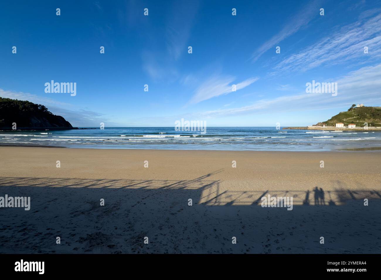 The shadow of a couple looking at Ribadesella beach from the promenade, Asturias, Spain - Smartphone Captured Stock Image