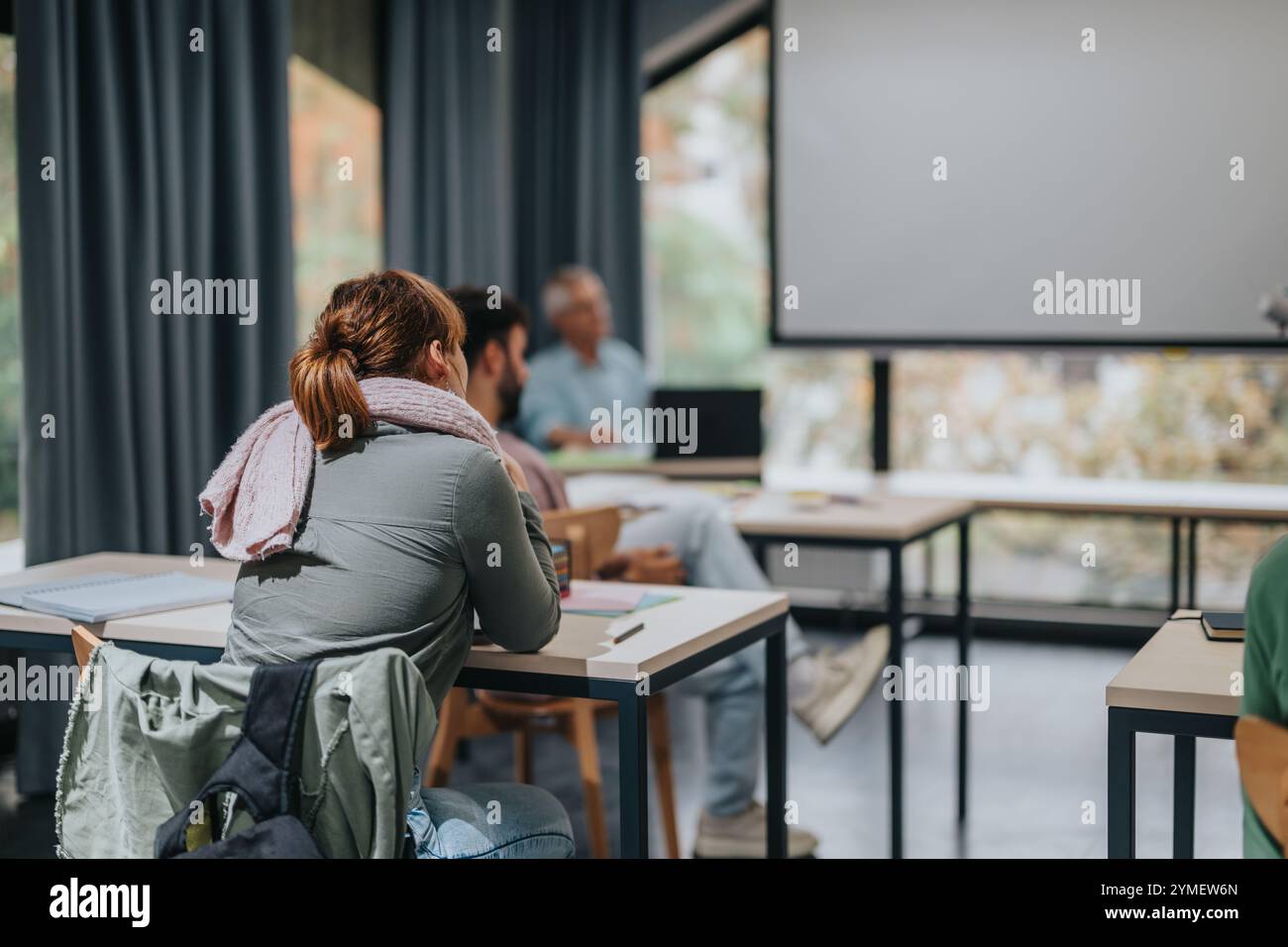 Engaged students in classroom with elderly professor teaching Stock Photo