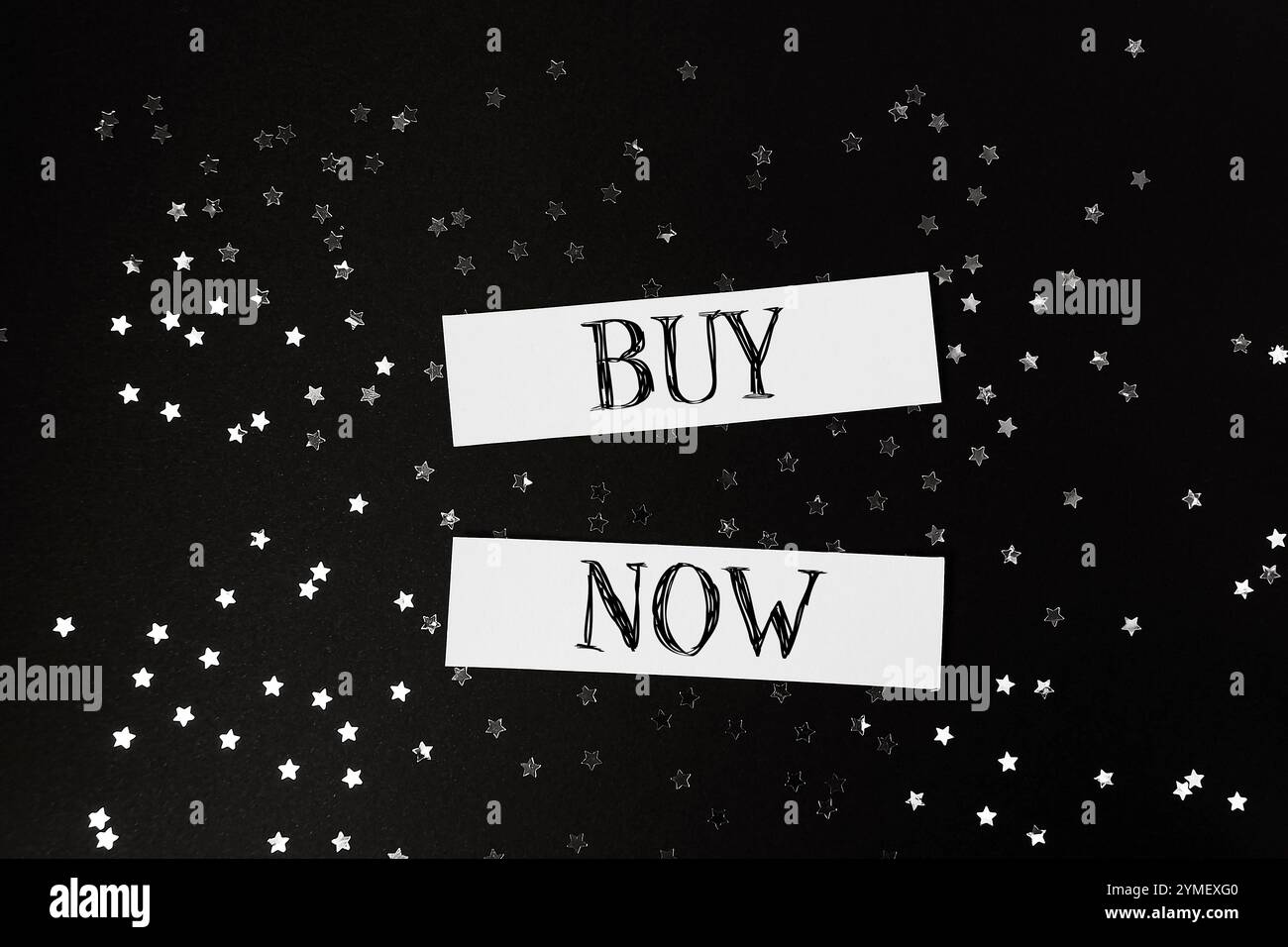 Buy now is written on a black background with stars. Concept of urgency and excitement, as if the viewer is being encouraged to make a purchase immedi Stock Photo