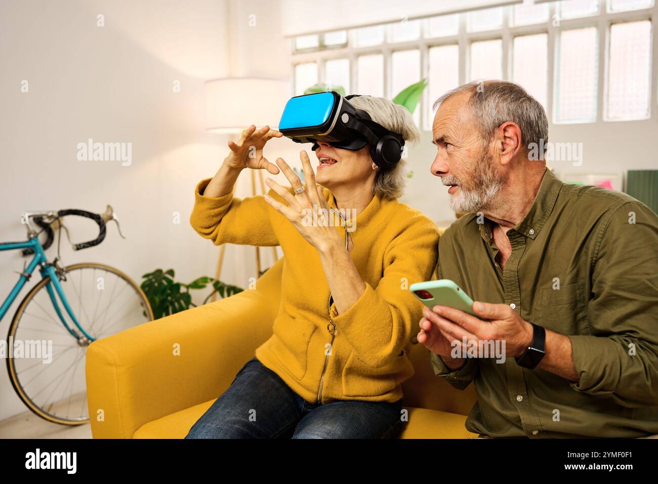 Senior couple exploring virtual reality at home Stock Photo