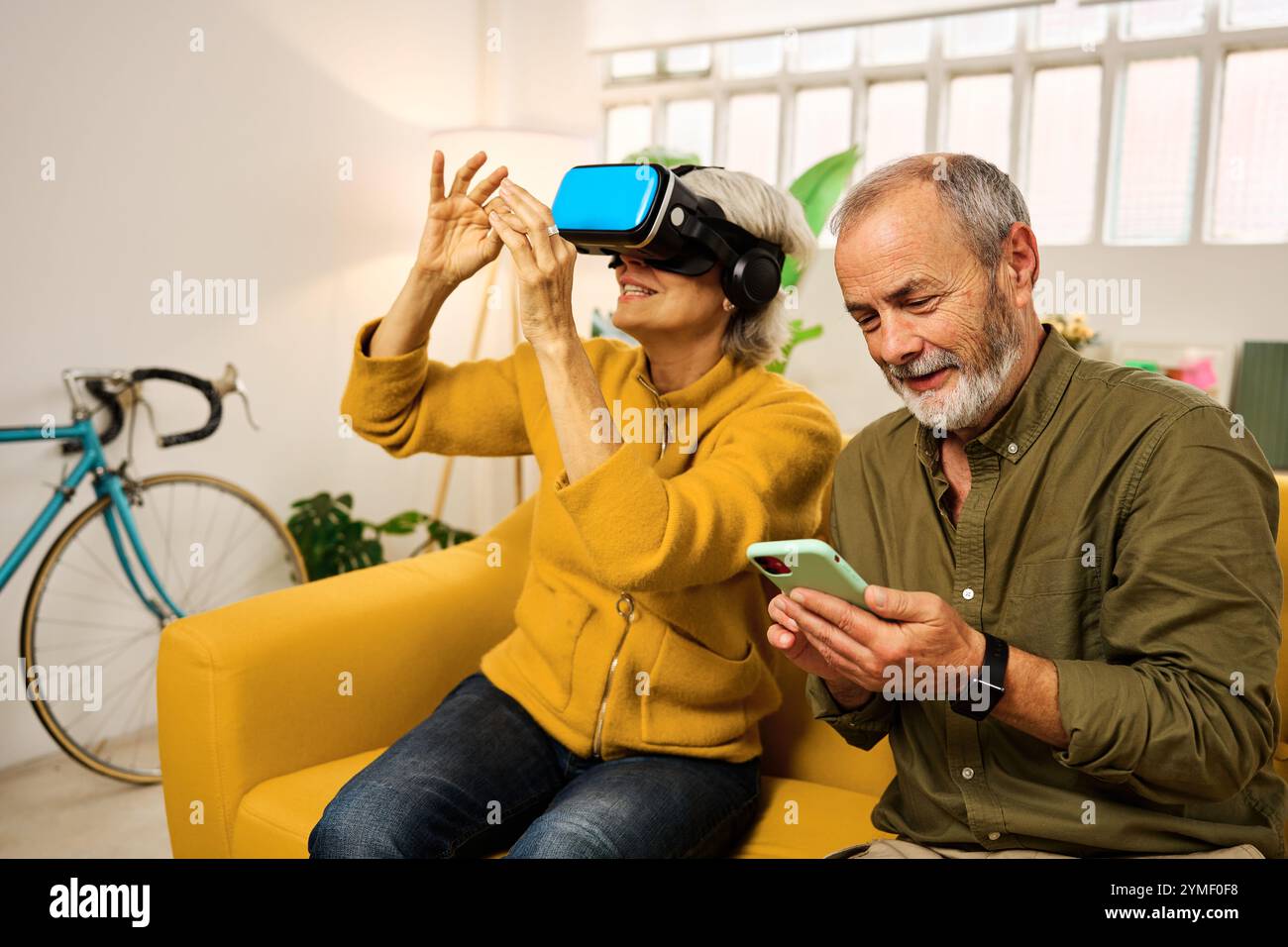 Senior couple exploring virtual reality at home Stock Photo