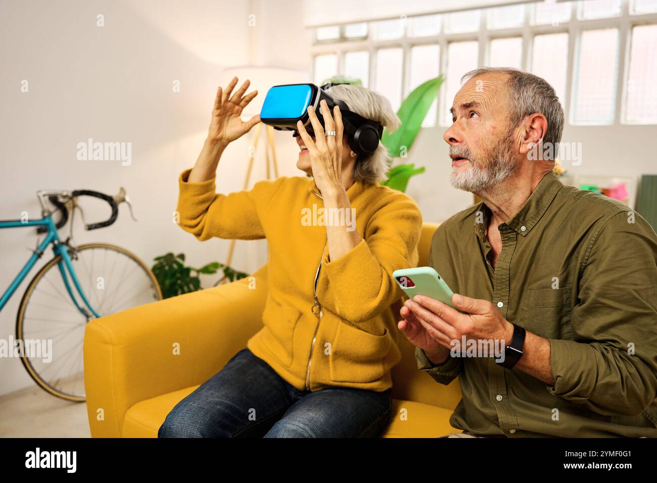 Senior couple exploring virtual reality at home Stock Photo