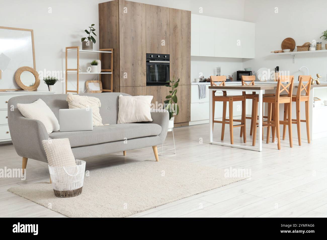 Interior of light kitchen with counters and laptop on sofa Stock Photo ...