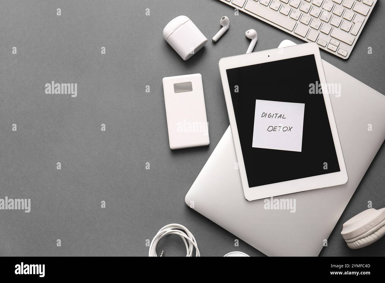 Sticky note with text DIGITAL DETOX and different modern gadgets on dark background Stock Photo