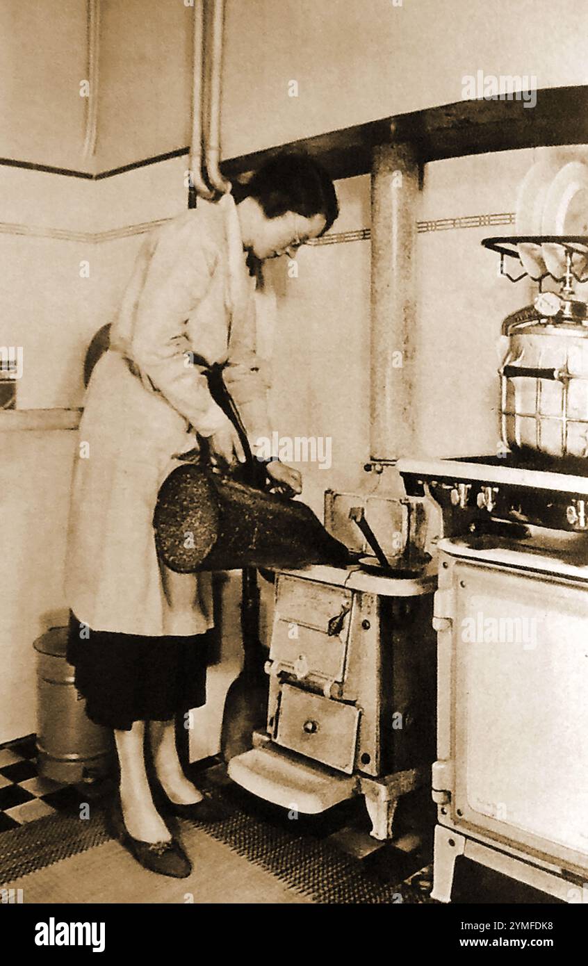 A Typical 1940 s British Housewife Filling Her Kitchen Stove With Coal 