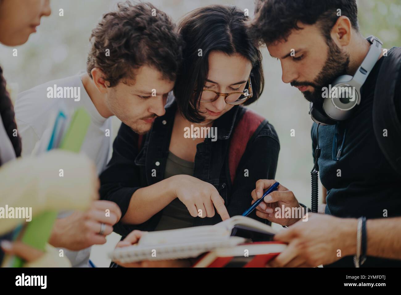 Diverse group of students collaborating on school work outdoors Stock Photo