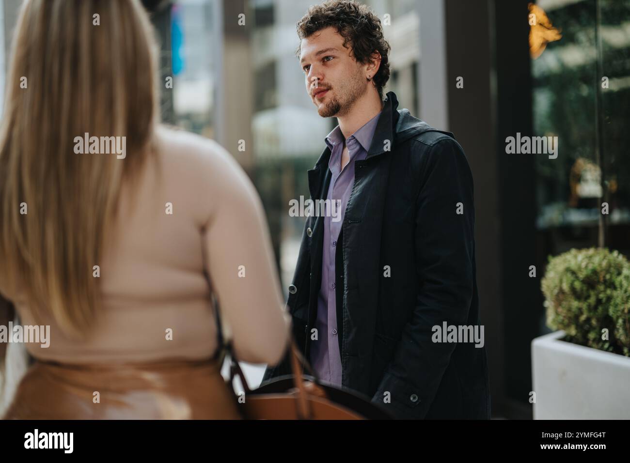 Candid outdoor conversation between two business professionals Stock