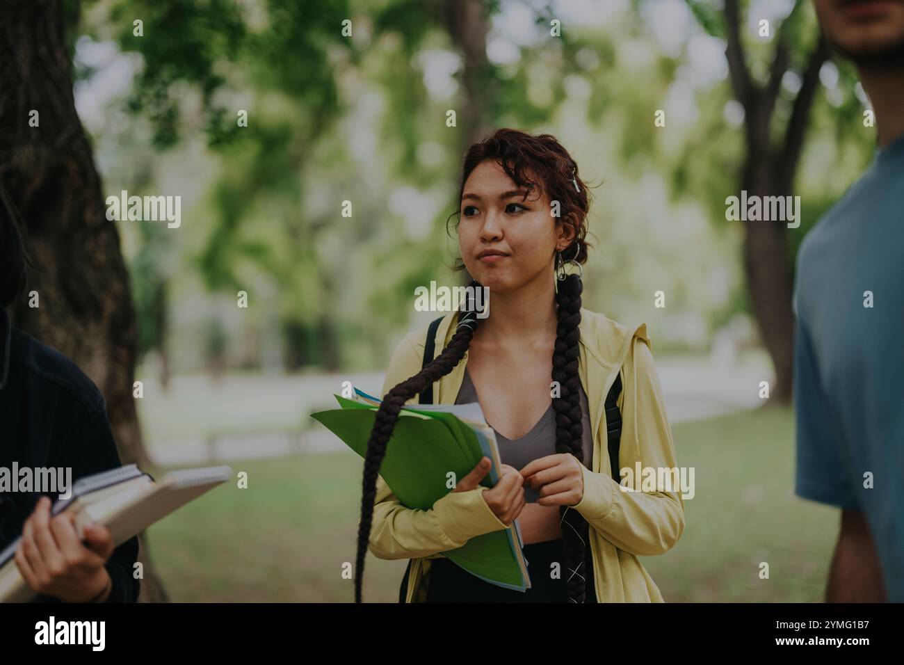 Multicultural students collaborating on school tasks in a park setting Stock Photo