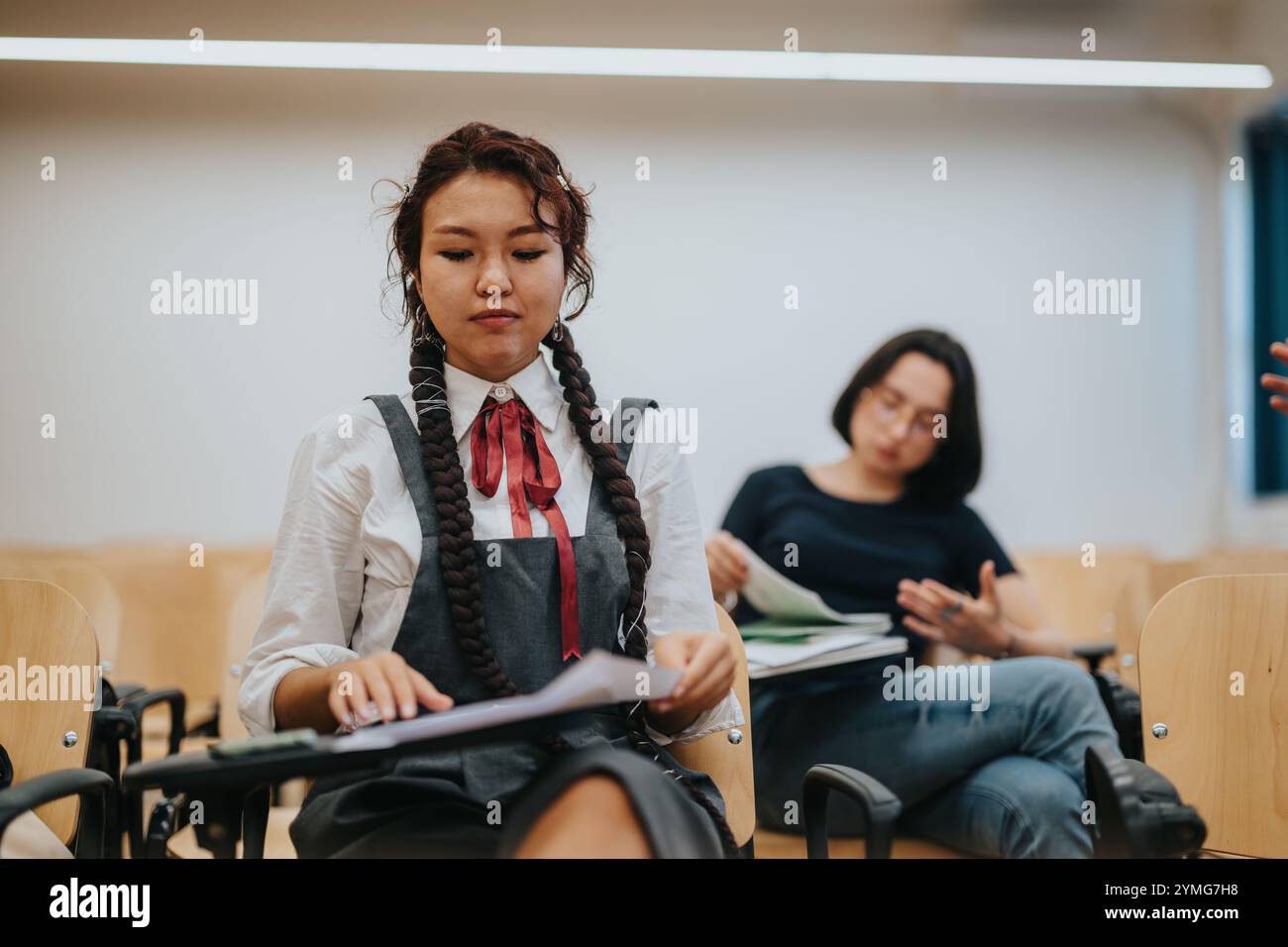 Students engaging with professor in classroom setting for discussion Stock Photo