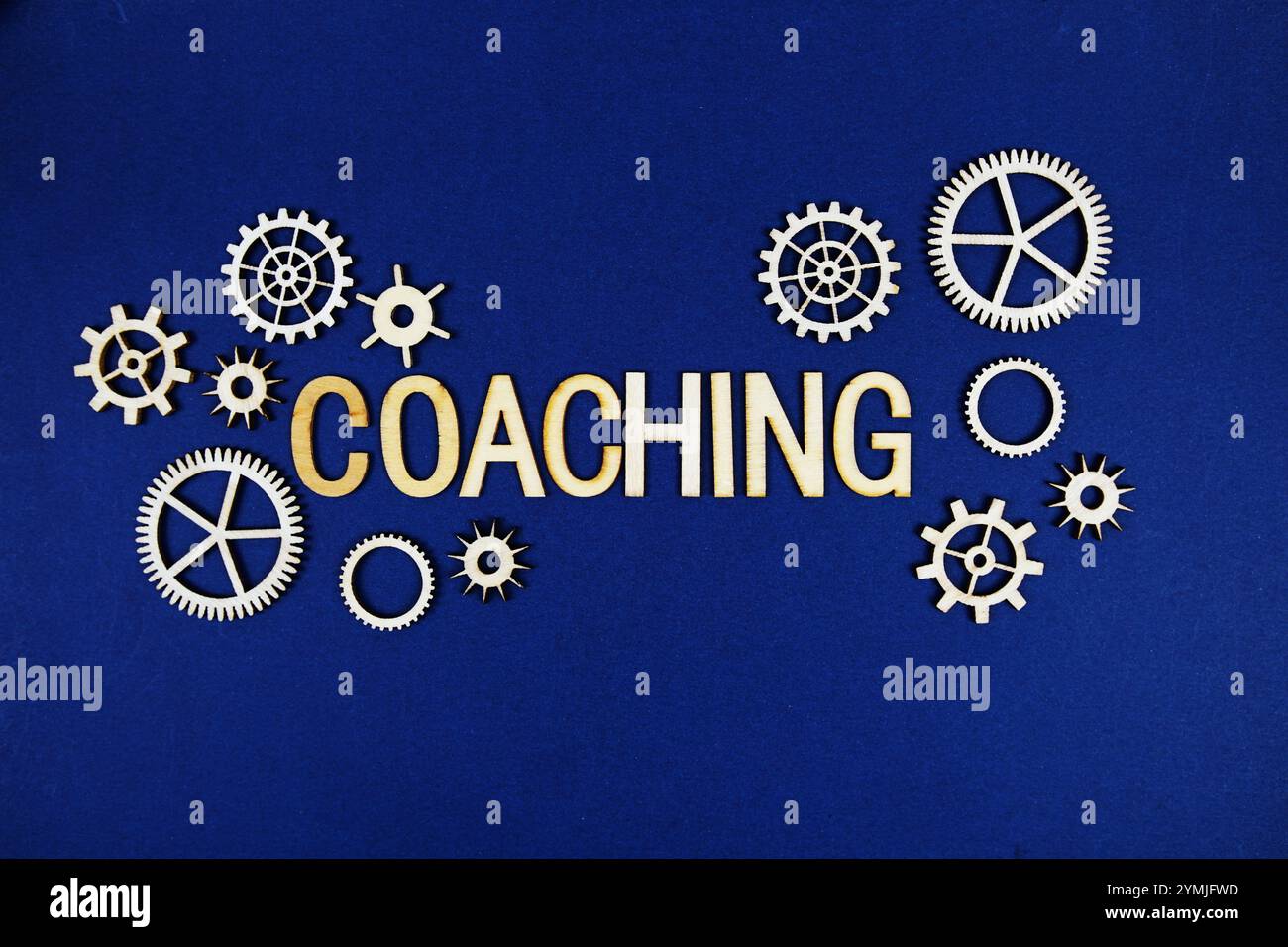 Coaching alphabet letters with gears element on navy blue background Stock Photo