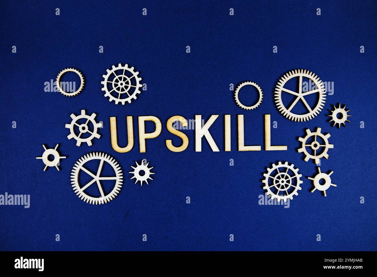 Upskill alphabet letters with gears element on navy blue background Stock Photo