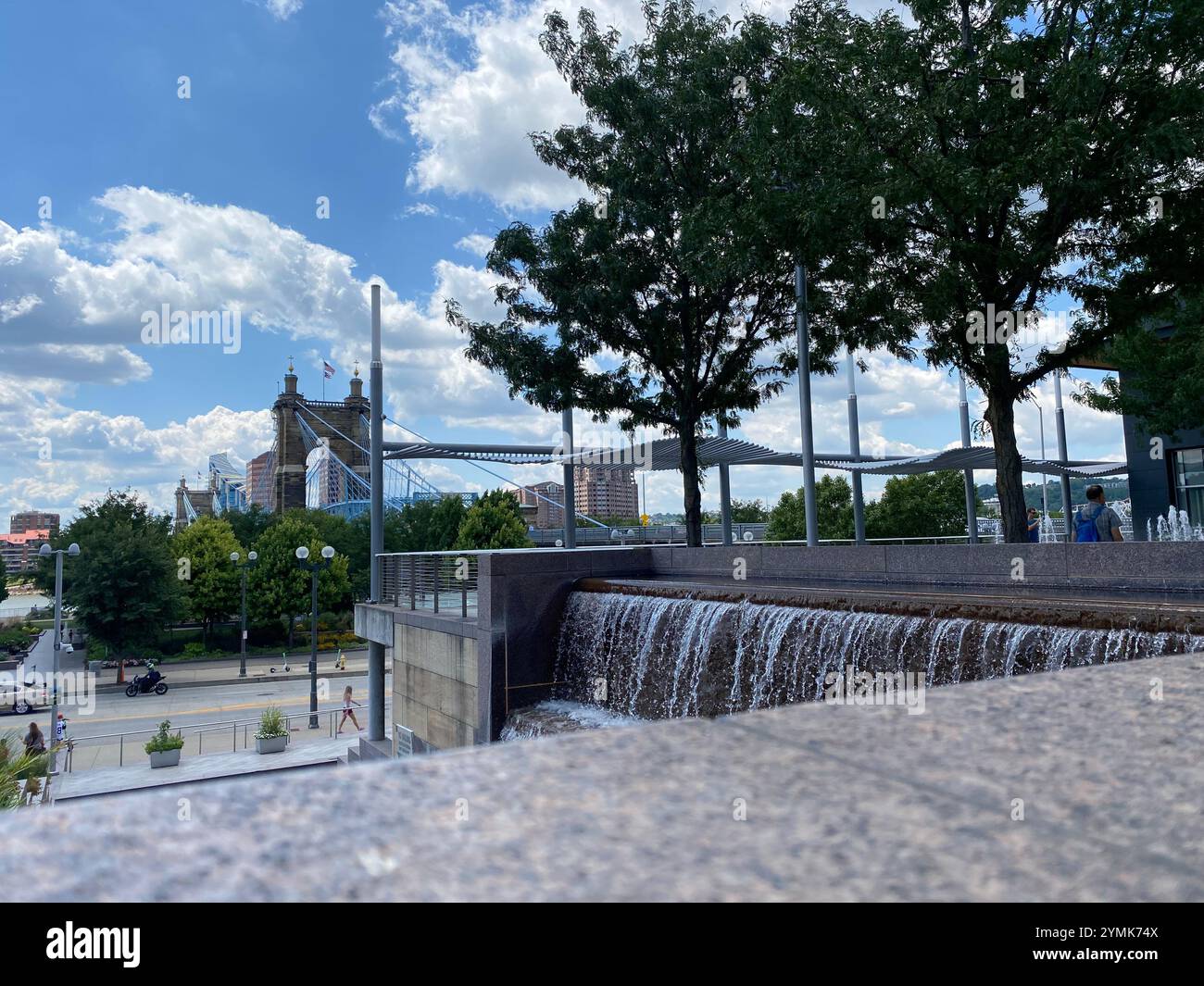 View of the John A. Roebling Suspension Bridge that spans the Ohio River between Cincinnati and Kentucky from a park on the Ohio side - Smartphone Captured Stock Image