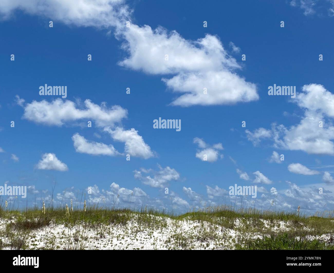 View of clouds in the blue sky over sand dunes - Smartphone Captured Stock Image