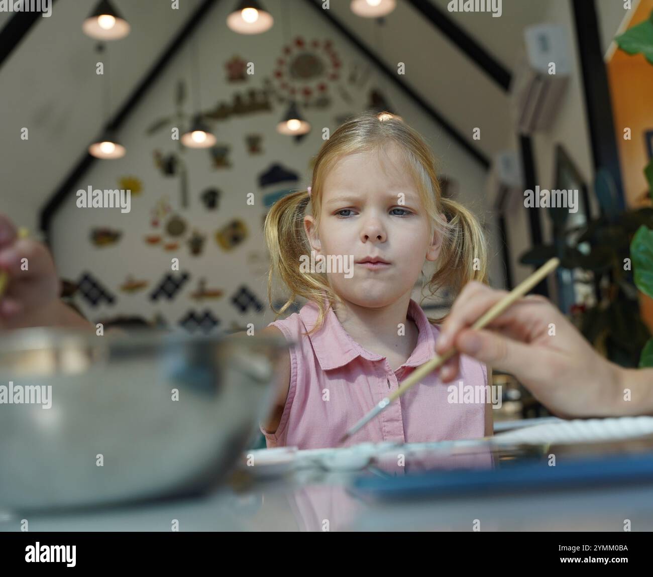 A young mother and her daughter enjoy a creative art session at home ...