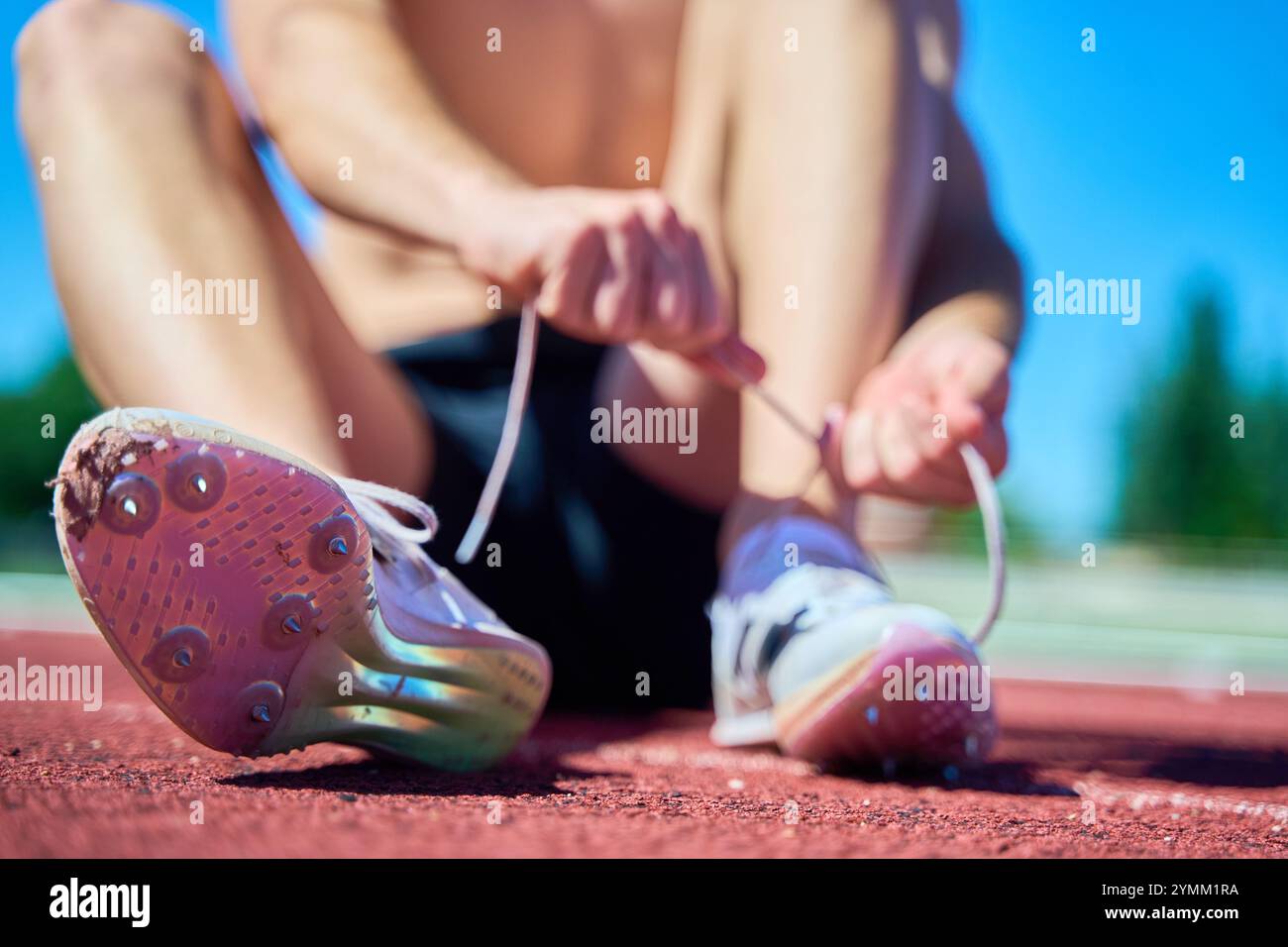 View of Athlete tying running shoes on track Stock Photo - Alamy