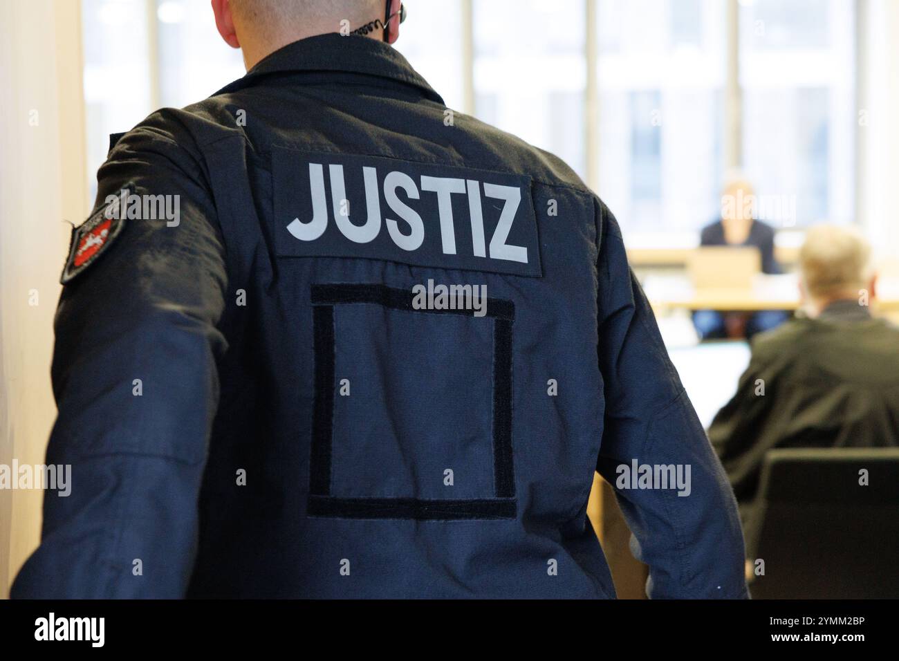 22 November 2024, Lower Saxony, Osnabrück: A court official stands in a courtroom at Osnabrück district court. The public prosecutor's office is accusing three defendants of attempted joint manslaughter, grievous bodily harm, extortion and robbery. They are said to have lured a 17-year-old girl into a forest near Meppen, assaulted her there and tied her up. The teenager was abused and injured for hours. Photo: Friso Gentsch/dpa Stock Photo