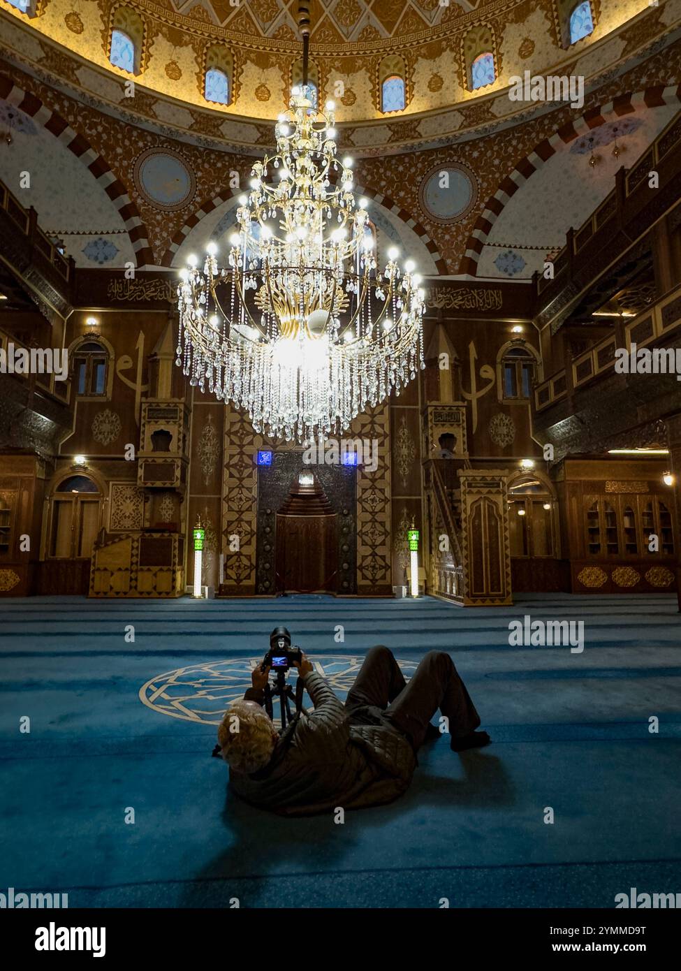 Photographer lying on the floor, using a tripod to photograph a ...