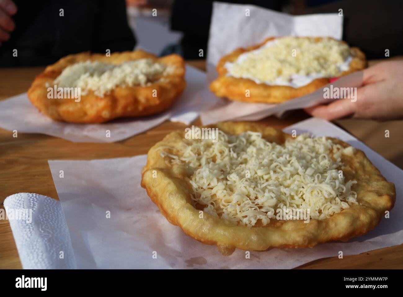 traditional hungarian fried street food colled langos on sheets of paper Stock Photo