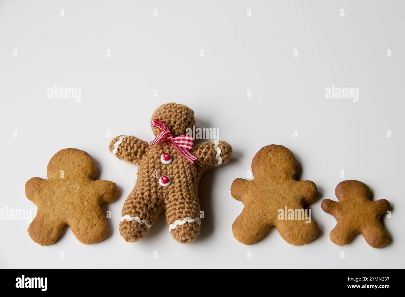 wool gingerbread man handmade chrochet near some gingerbread biscuits, copy space Stock Photo