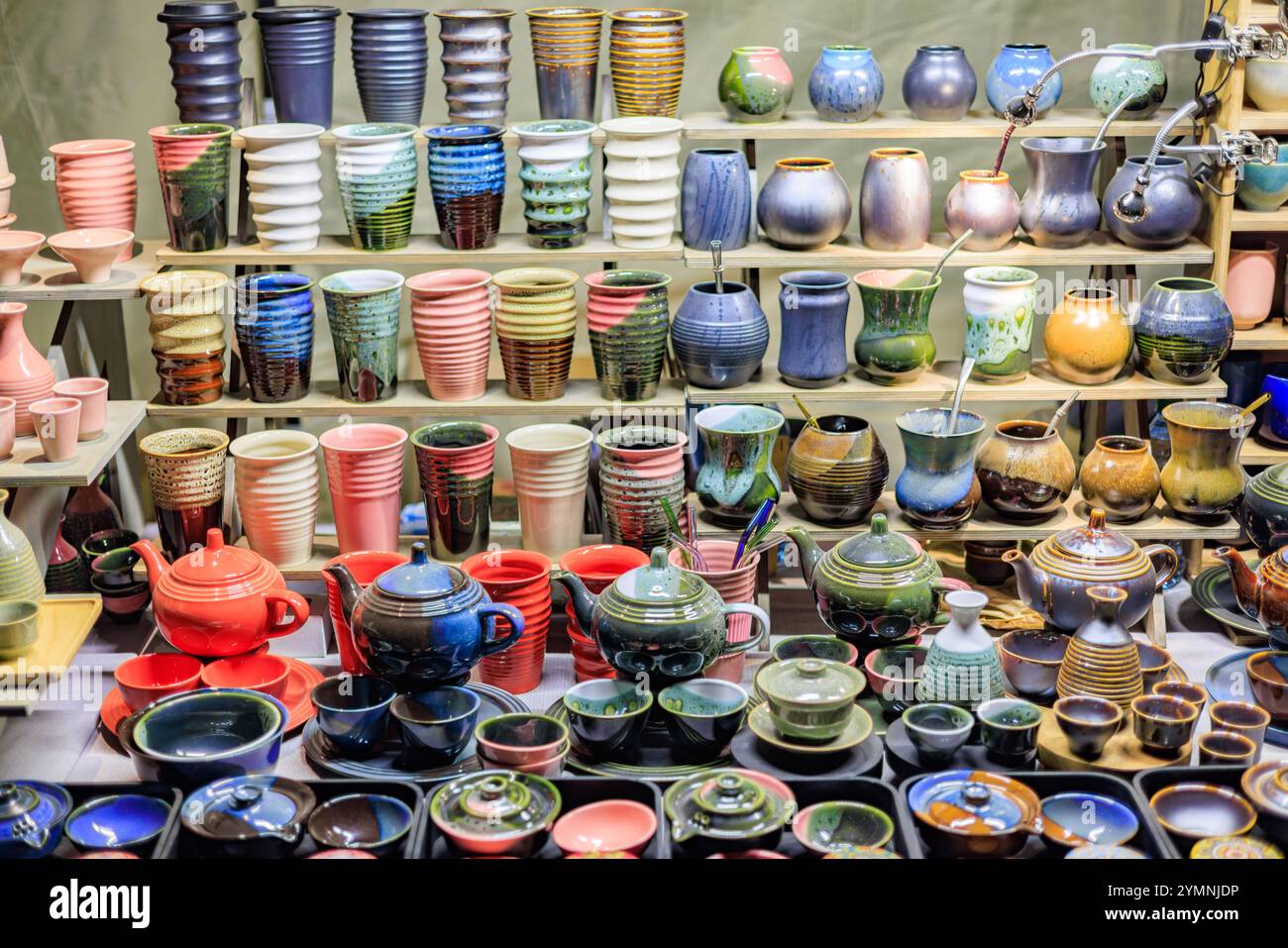 A counter with beautiful ceramic teapots and cups of various shapes and colors. Stock Photo