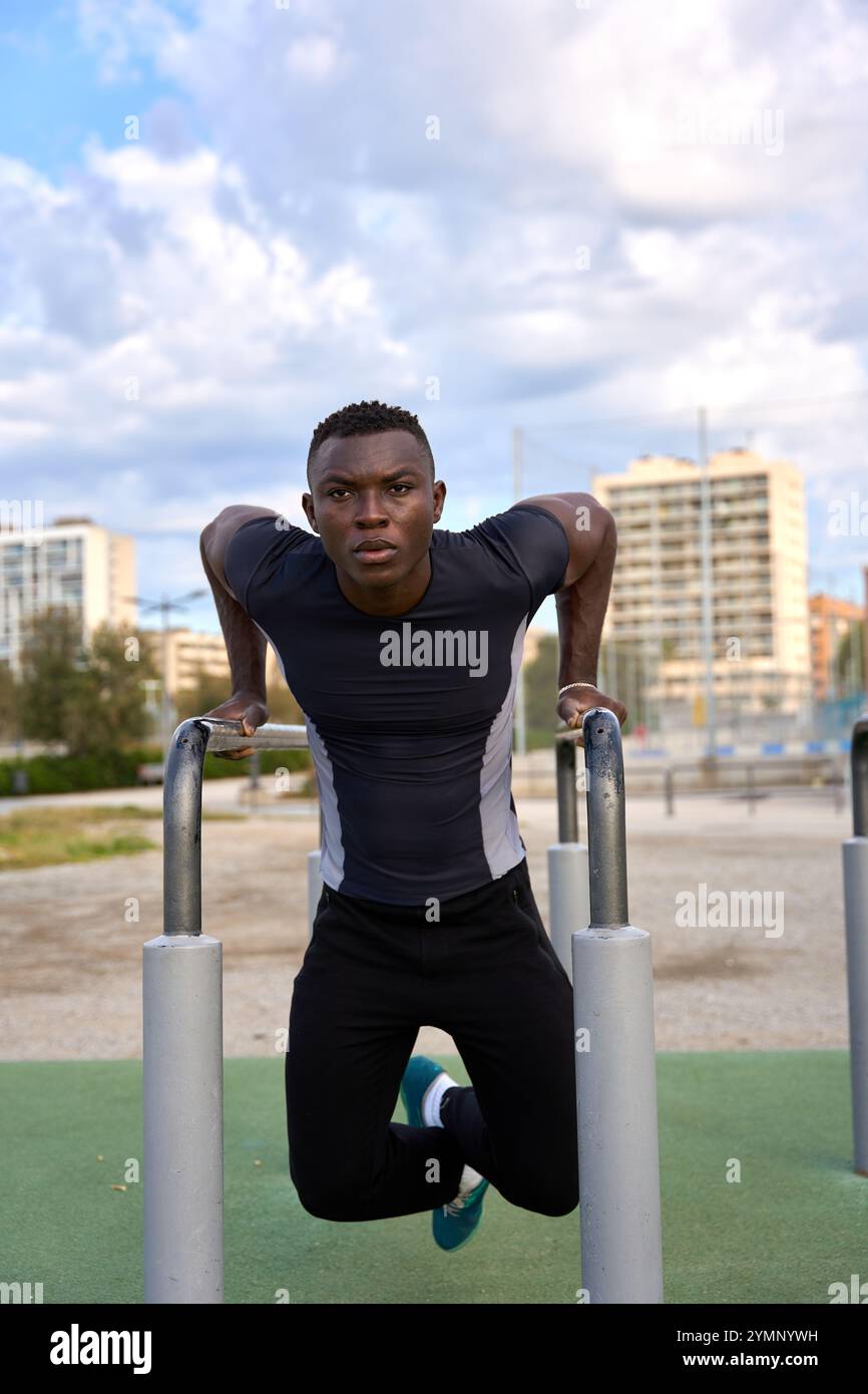 Young black man performing calisthenics dips in an outdoor gym Stock ...