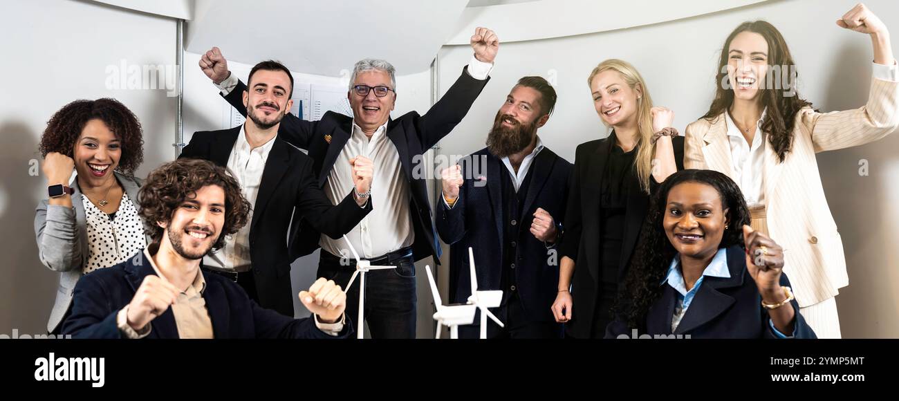 Diverse business team celebrating success with raised fists and joyful ...
