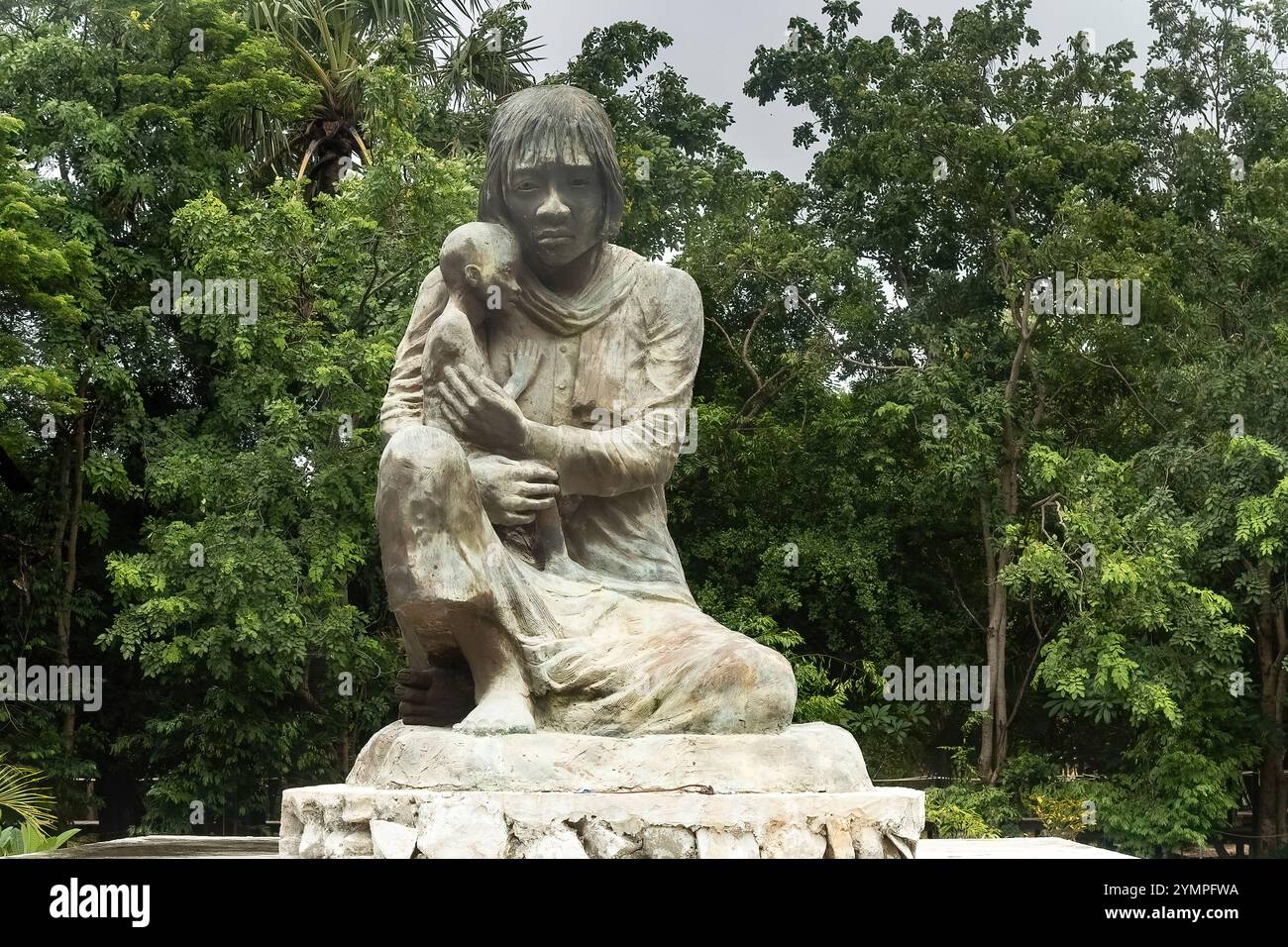 Carved statue of a women holdingh her child at Cheong Ek Killing Fields memorial Stock Photo