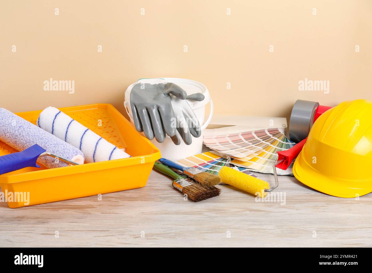 Different painter's tools on light wooden table. Decorating and design Stock Photo