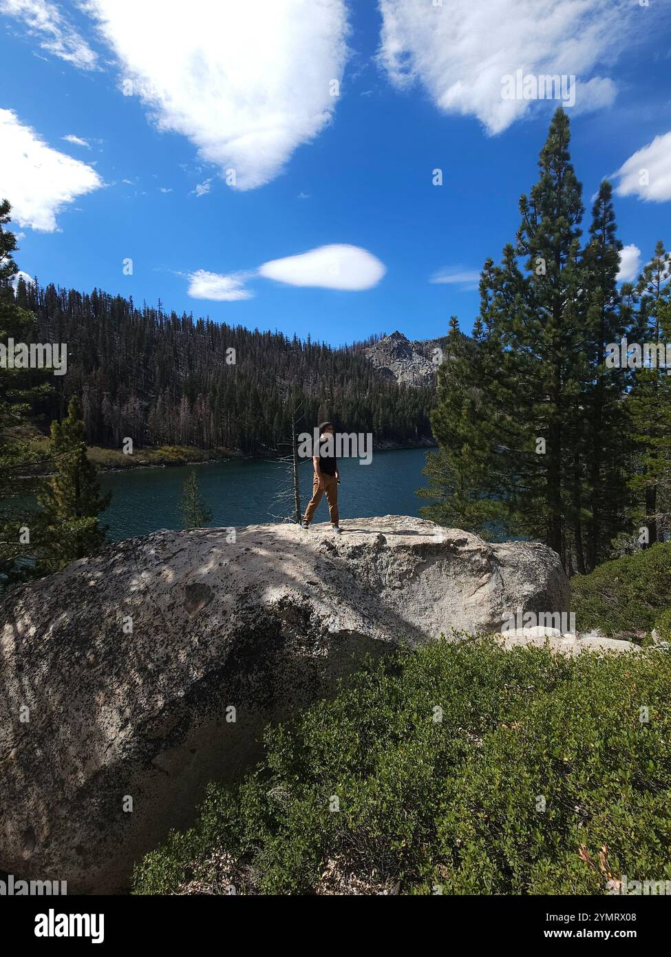 'Scenic mountain landscapes with hiking trails, lush greenery, serene lake views, and a traveler enjoying nature. Perfect for outdoor adventure and tr - Smartphone Captured Stock Image