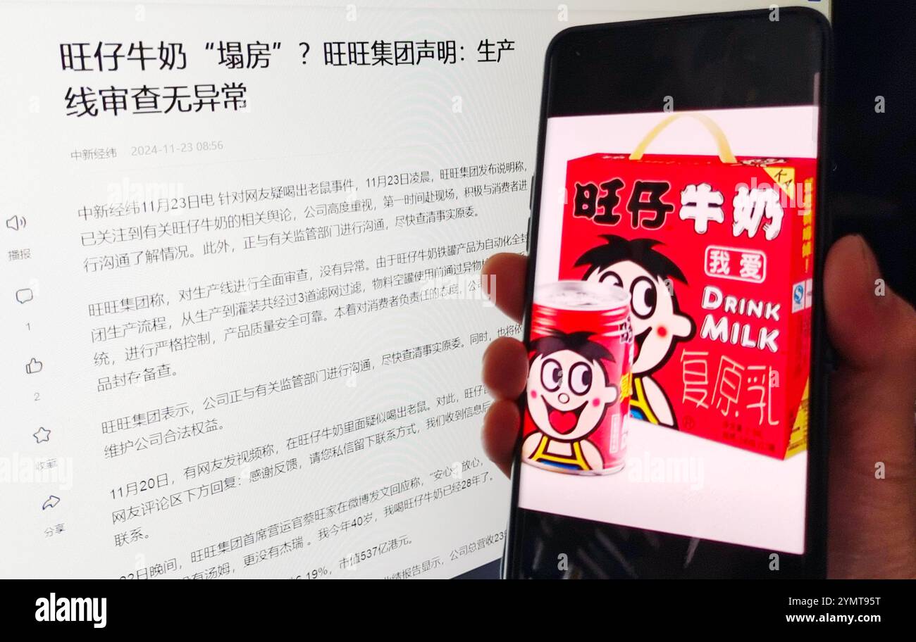 A consumer shows a screenshot of Wangzai milk e-commerce products and a news report of Want Want Group's response, November 23, 2024, Shanghai, China. Stock Photo